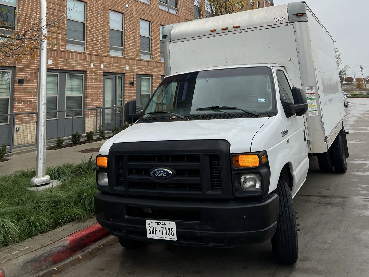 Hernandez Moving LLC box truck parked outside an apartment building in Garland, TX
