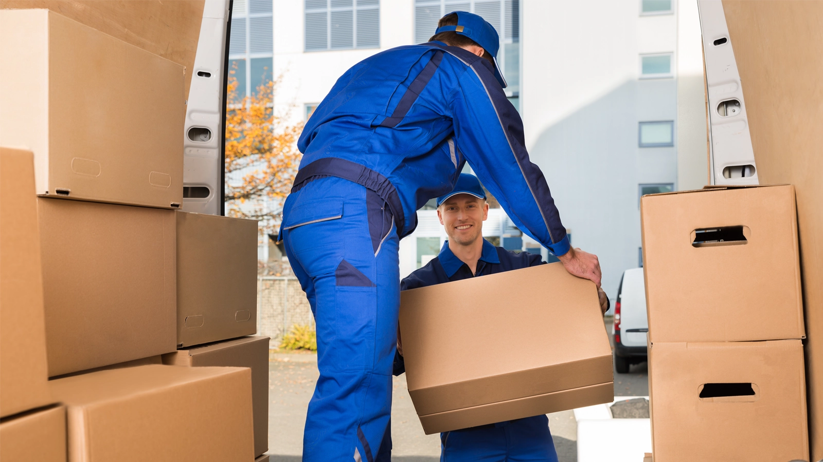 Hernandez Moving LLC mover carrying packed boxes to the truck